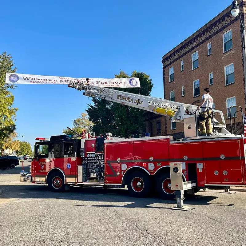 Firefighters on truck putting up parade banner